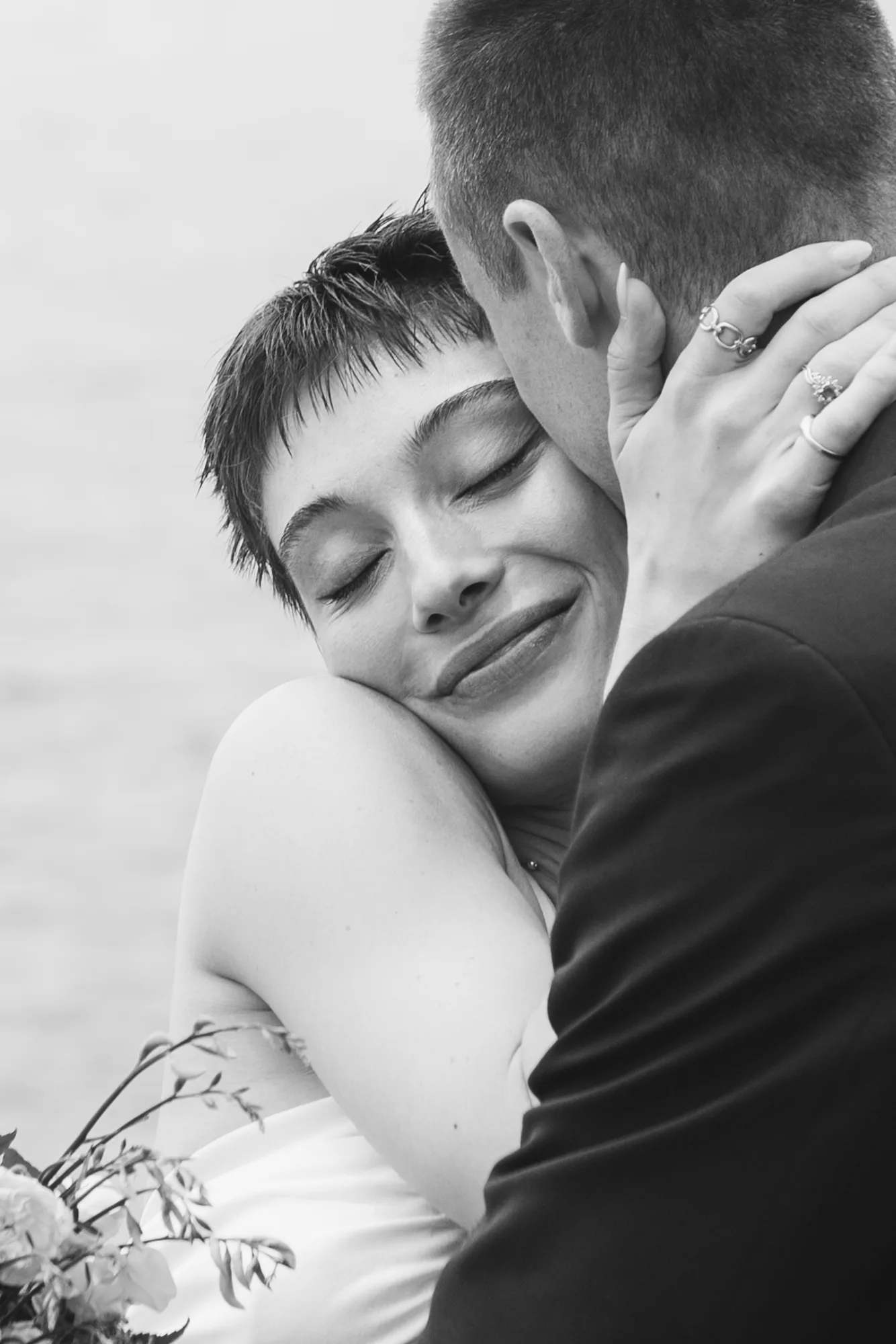 The photograph is in black and white, showing a close-up of a couple embracing.