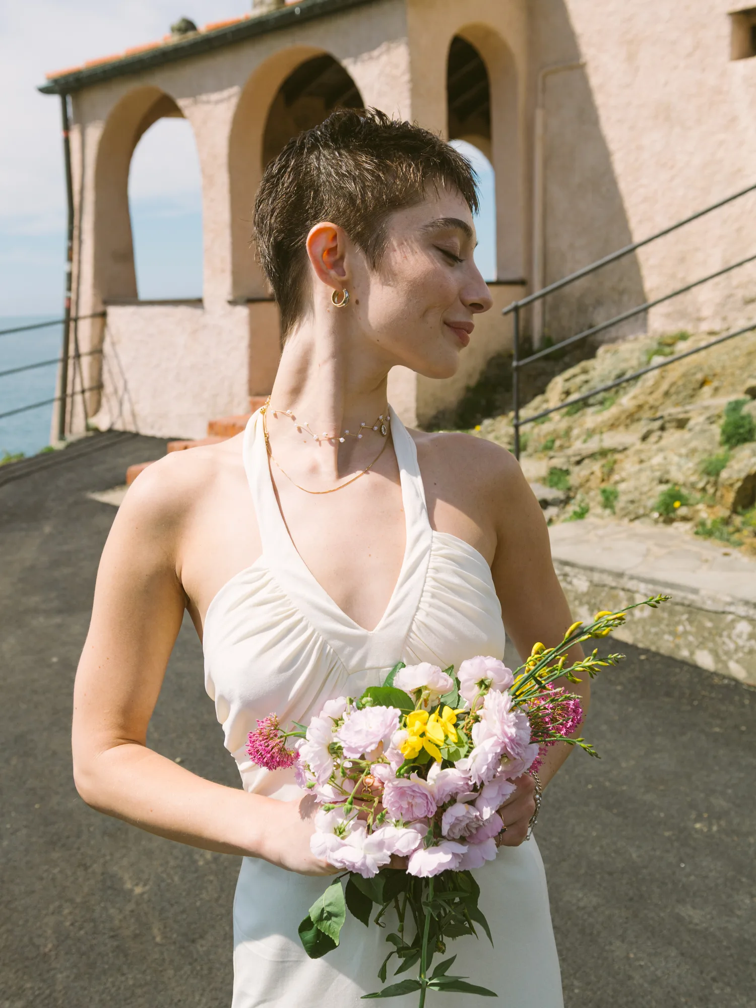 A bride in a white dress holds a bouquet of flowers.