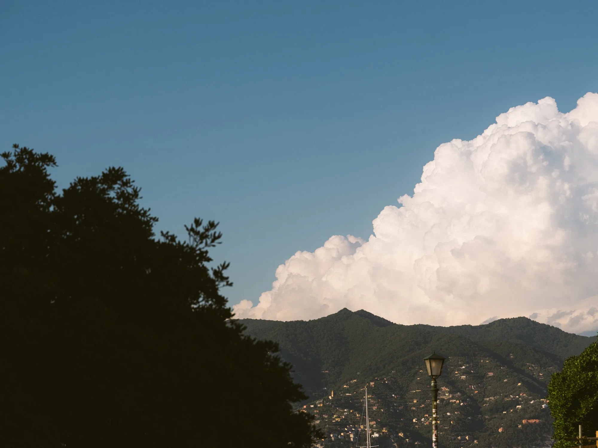 The photograph shows a clear blue sky with a large, fluffy white cloud formation.