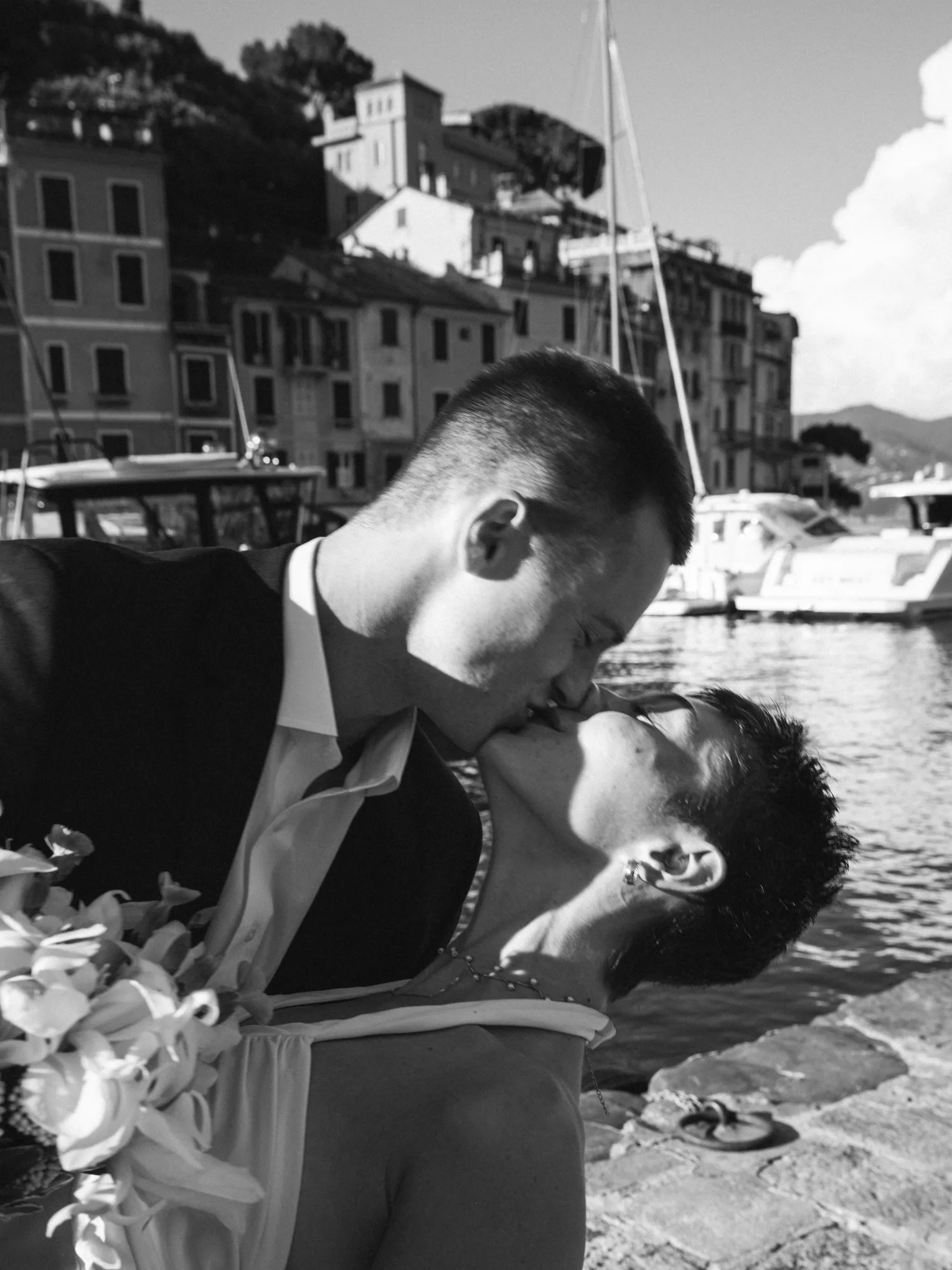 A man and a woman are embracing on a dock.