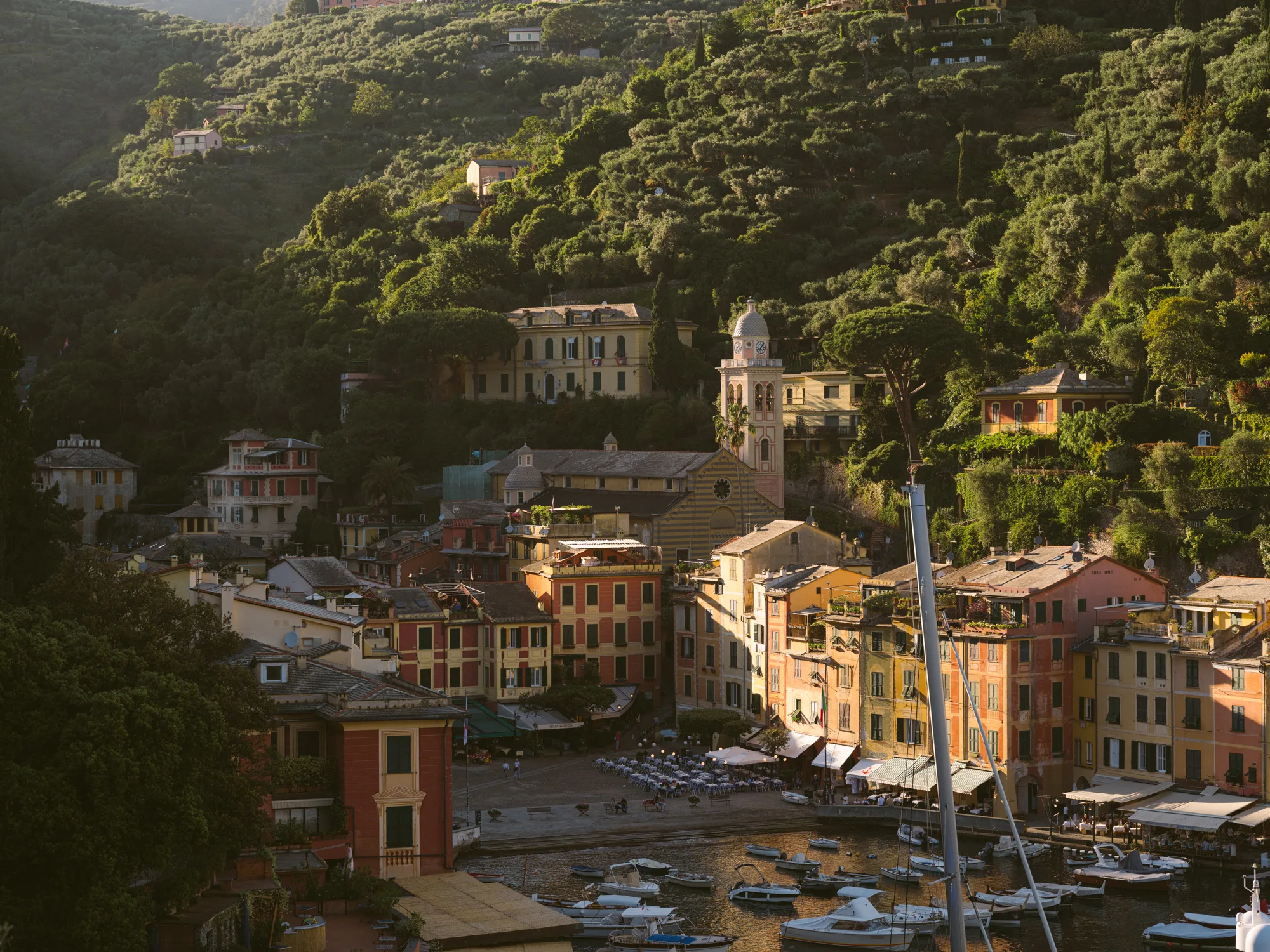 The photograph shows a picturesque coastal town with colorful buildings and a church with a tall bell tower.