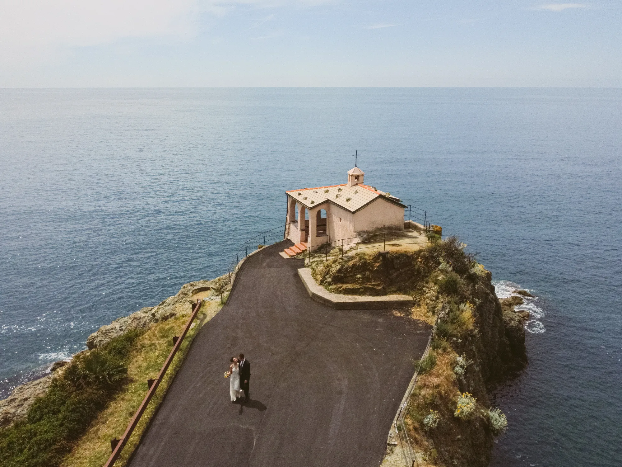 Cappella della Madonnina della Punta on top is situated on a rocky cliff overlooking the ocean.