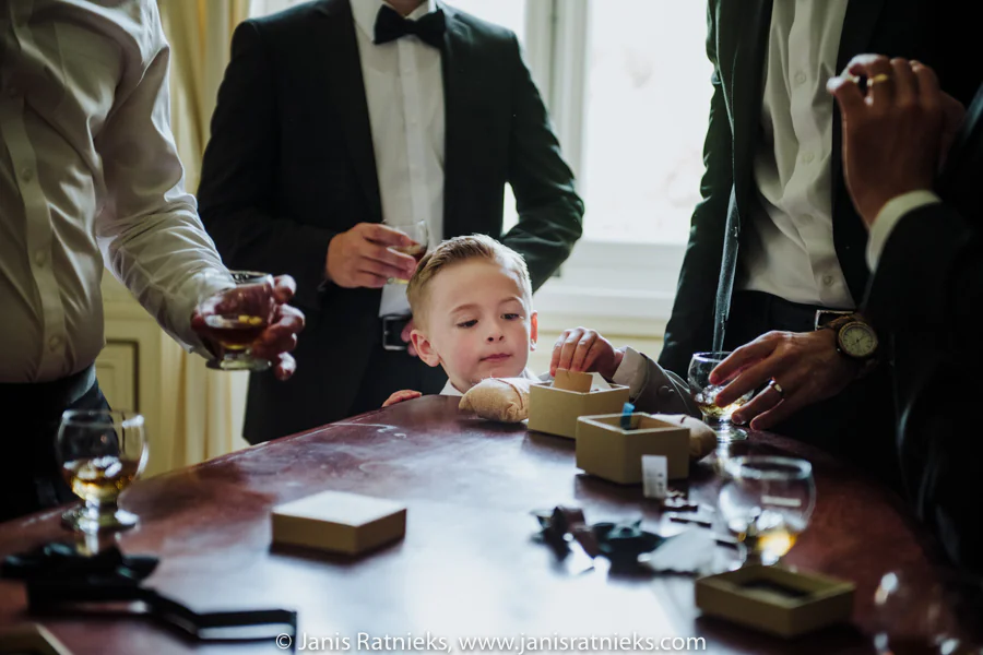 Young ring bearer standing among Ramon’s groomsmen