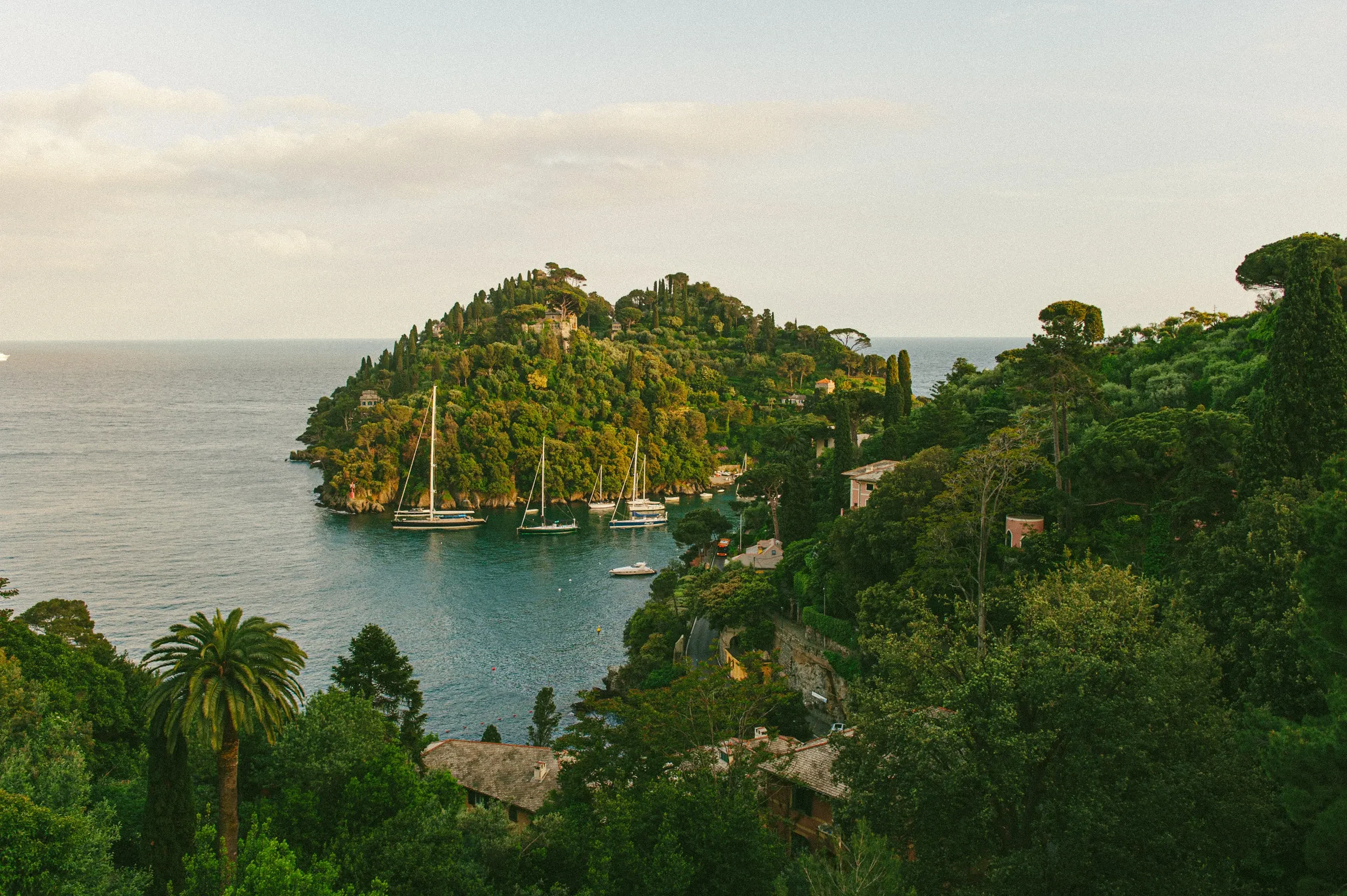 Green headland and boats along the Ligurian coast near Portofino