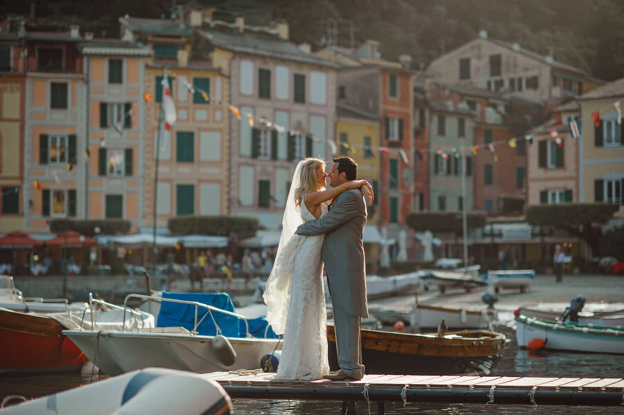 Anna and Brian embracing beside the water in Portofino harbour