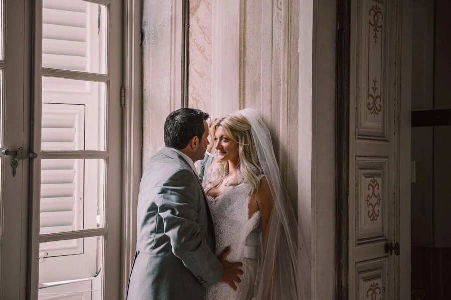 Anna and Brian sharing a quiet moment beside a window inside Villa Durazzo