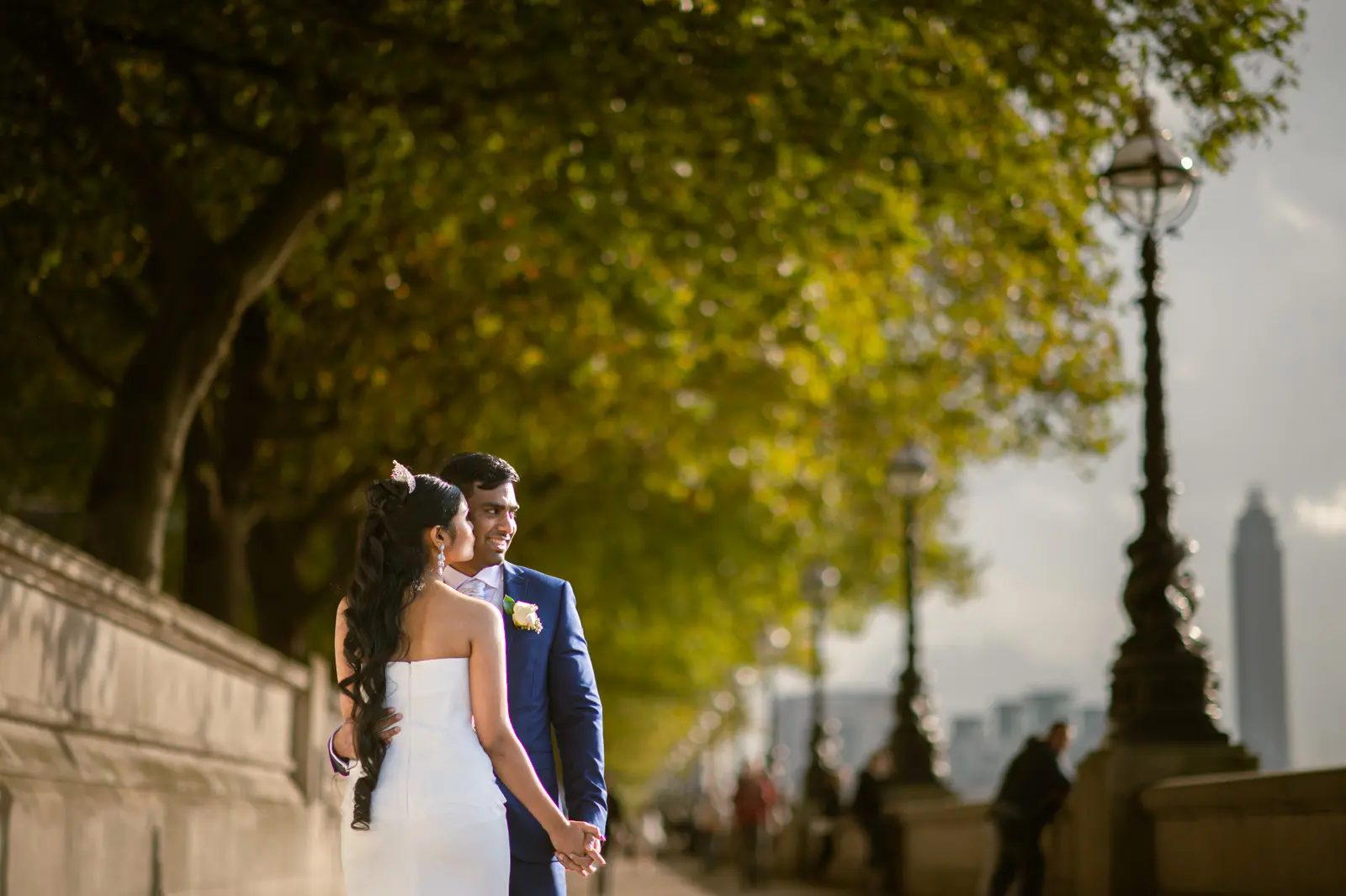 Couple walking through warm autumn light during a London pre-wedding photoshoot