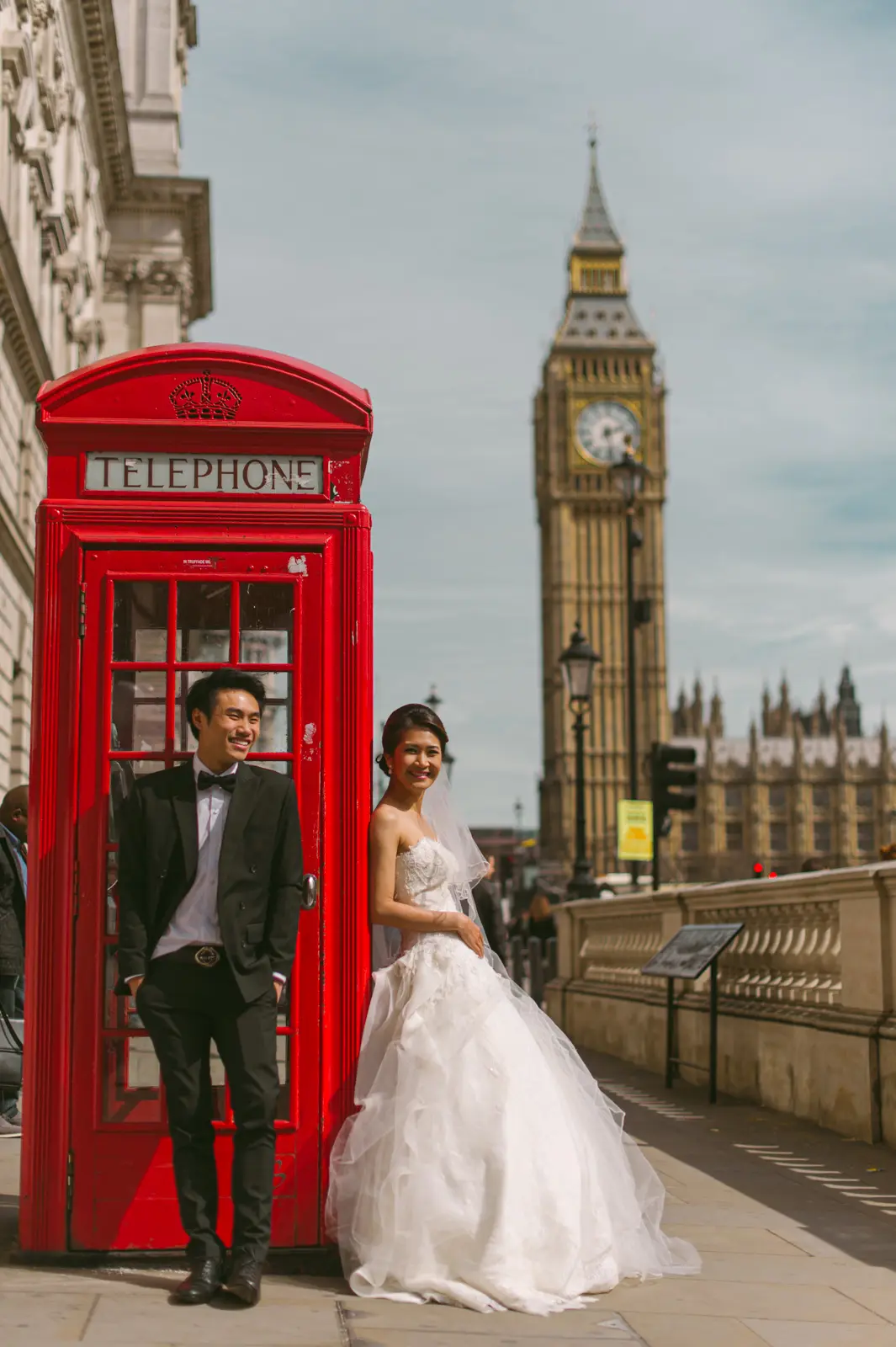 London pre-wedding portrait beside a red telephone box with Big Ben behind the couple