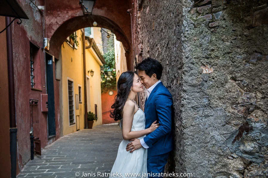 Couple embracing beneath an old stone arch in a Portofino lane