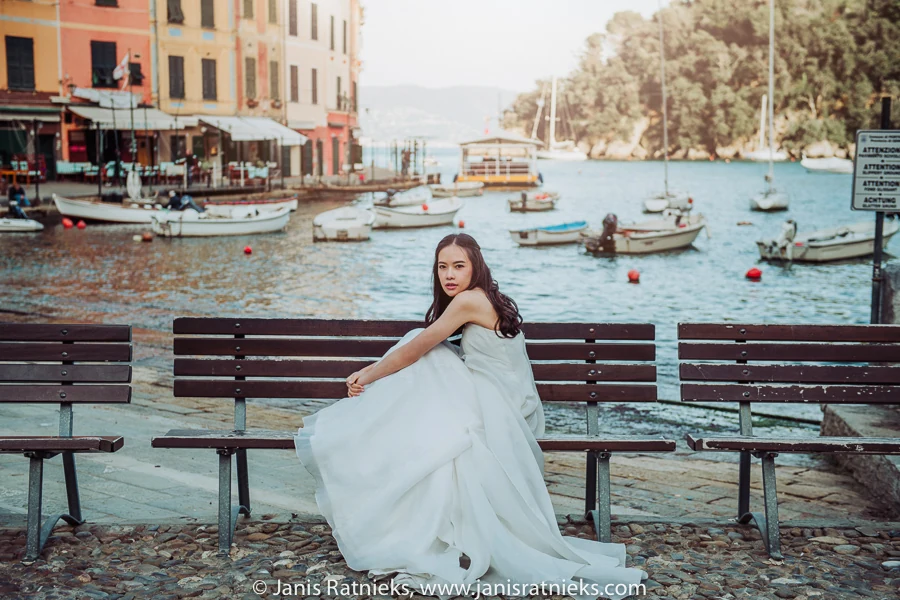 Bride seated beside the water with Portofino harbour behind her