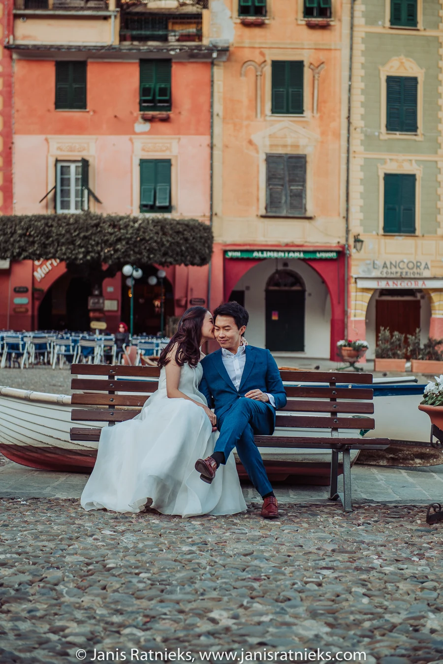 Couple seated together on a bench beside Portofino harbour