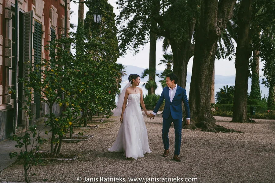 Couple walking through the tree-lined gardens of Villa Durazzo