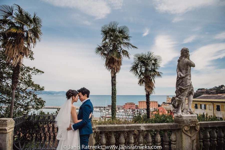 Couple framed by statues and the sea view from Villa Durazzo