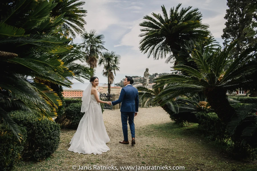 Couple walking through palms in Villa Durazzo’s Italian Garden