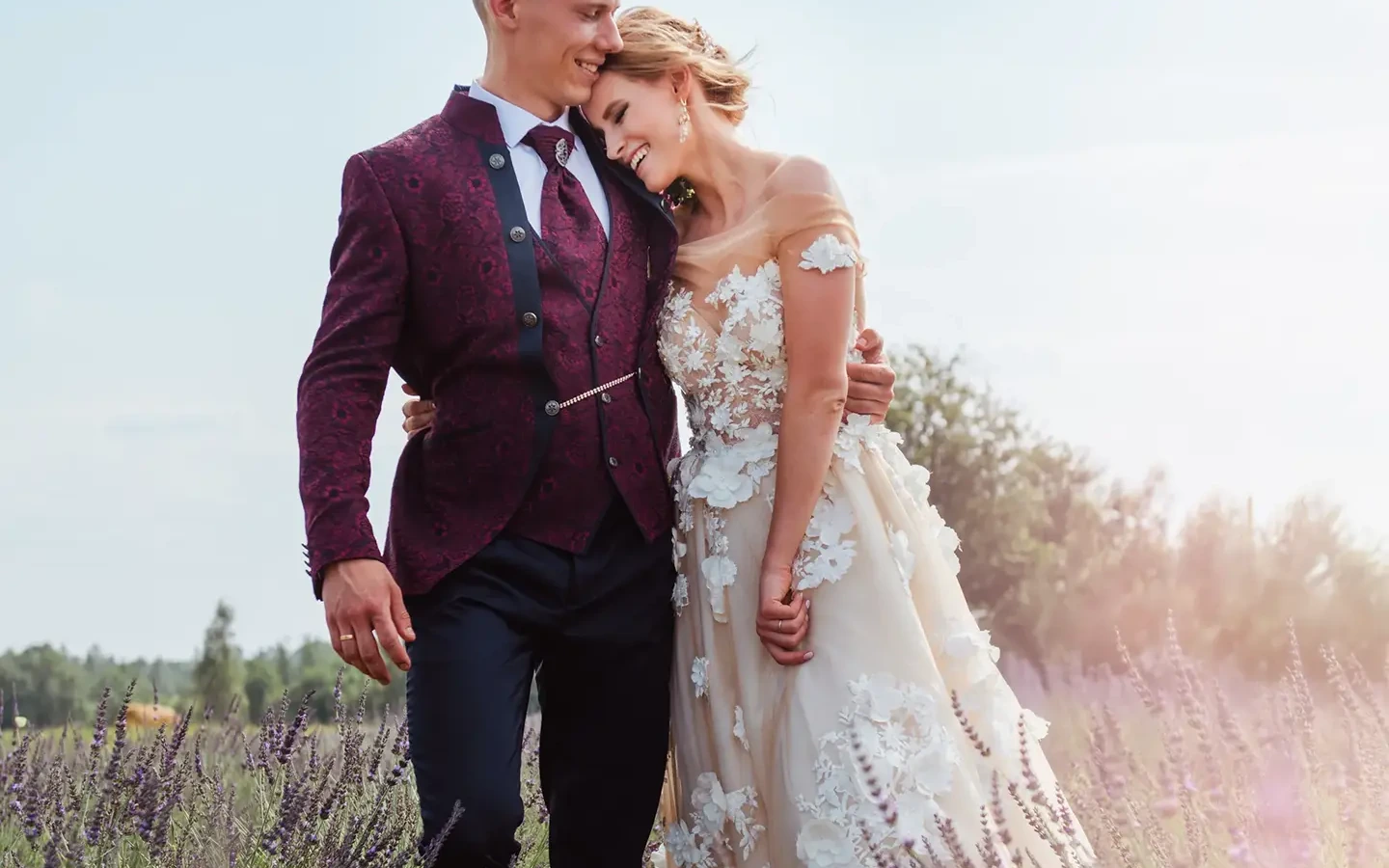 Bride and groom standing in a lavender field in the warm evening light