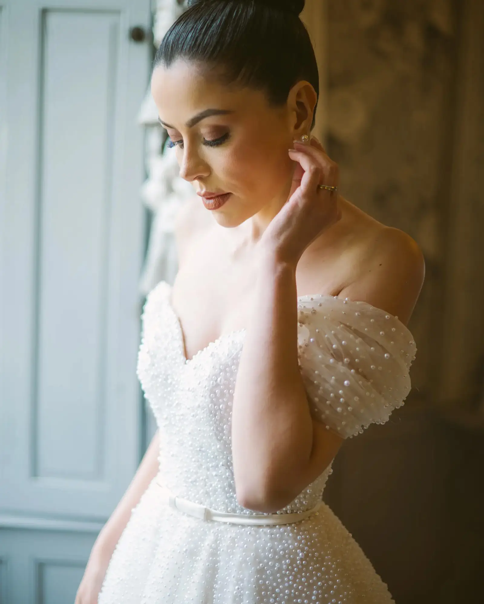 Bride preparing beside a château window during a South of France wedding