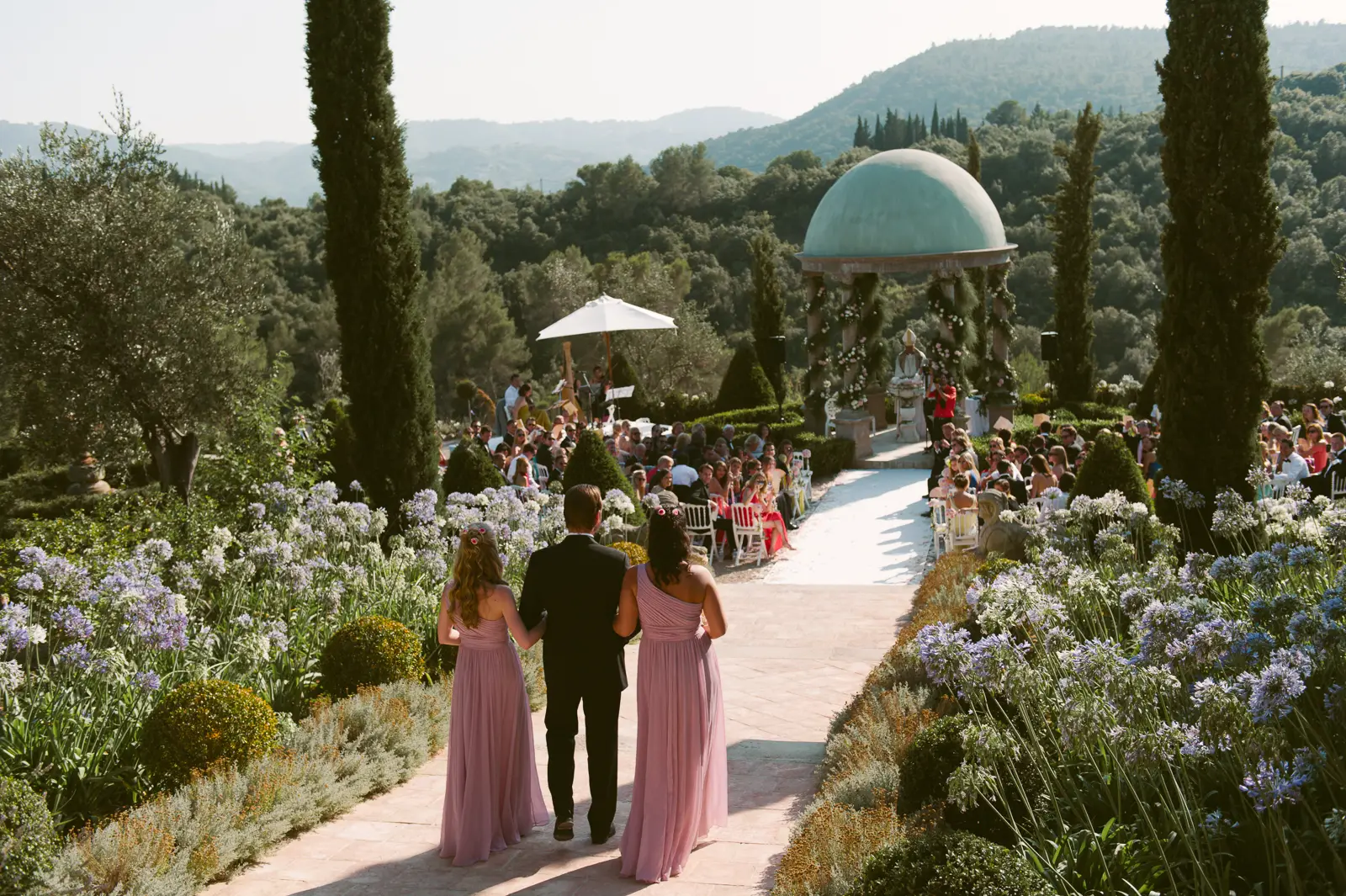 Wedding ceremony procession through a formal garden in the South of France