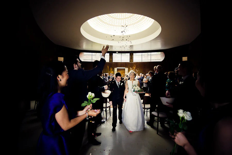 Bride and groom leaving their Eltham Palace wedding ceremony through confetti