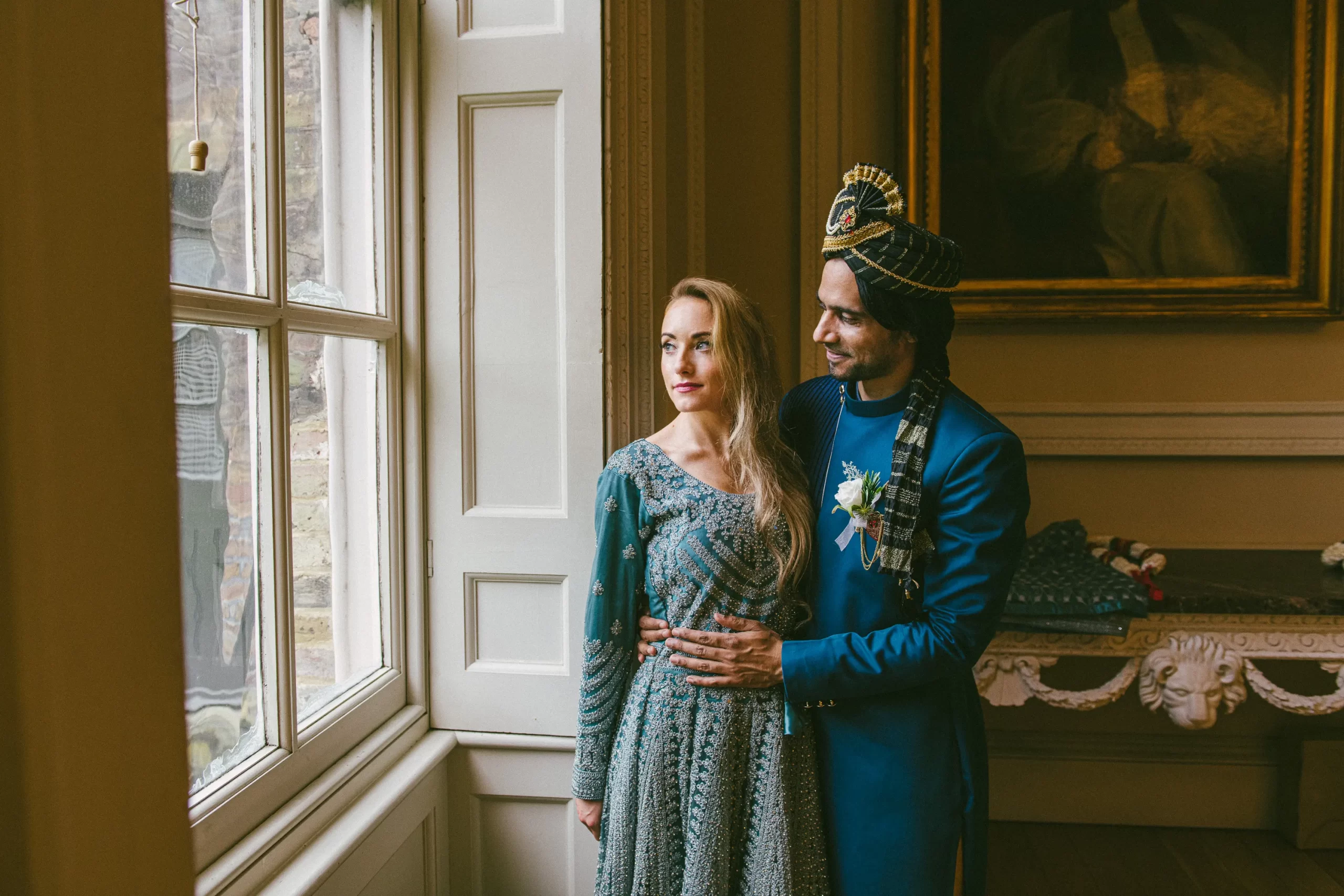 Bride and groom beside a window inside Fulham Palace