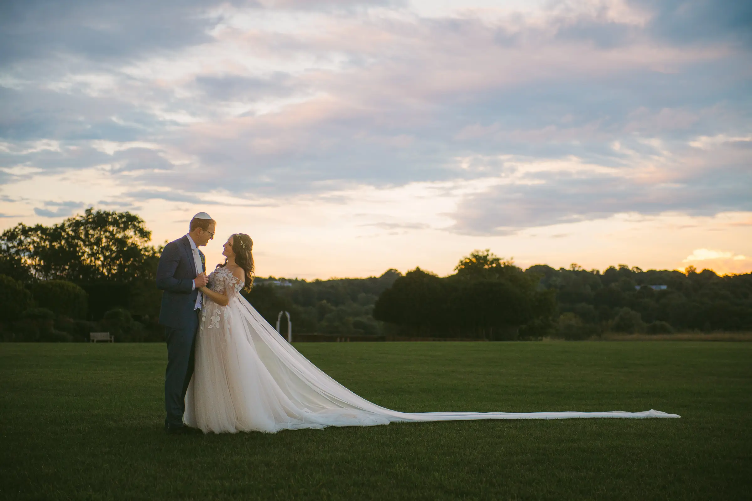 Bride and groom portrait at sunset on a wide lawn