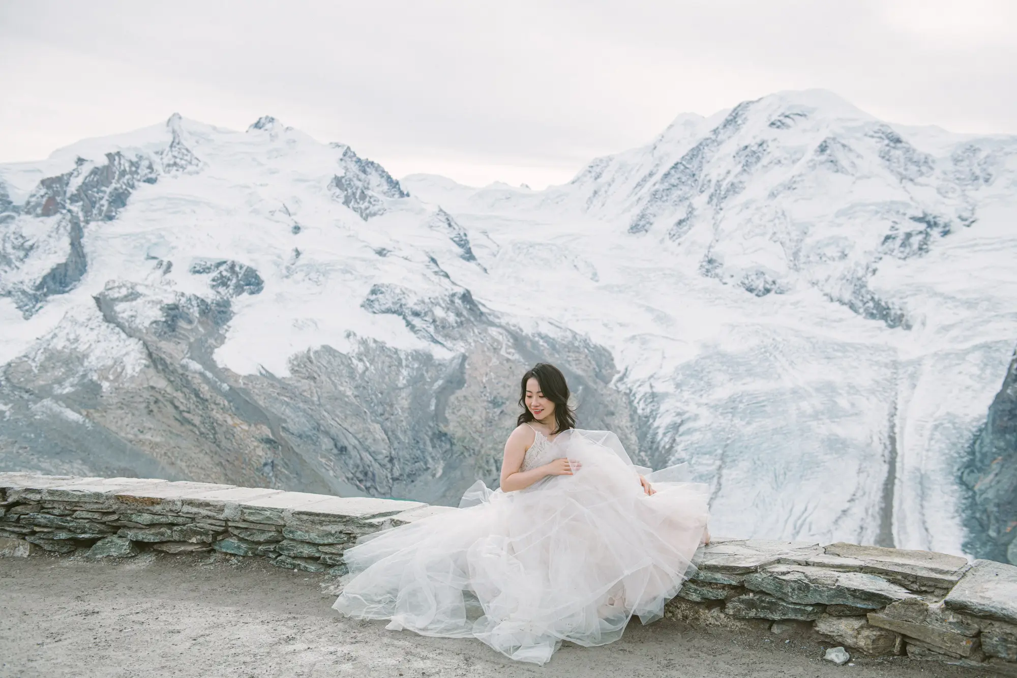 Image 6: Bride and groom standing on a viewpoint above the Swiss mountains