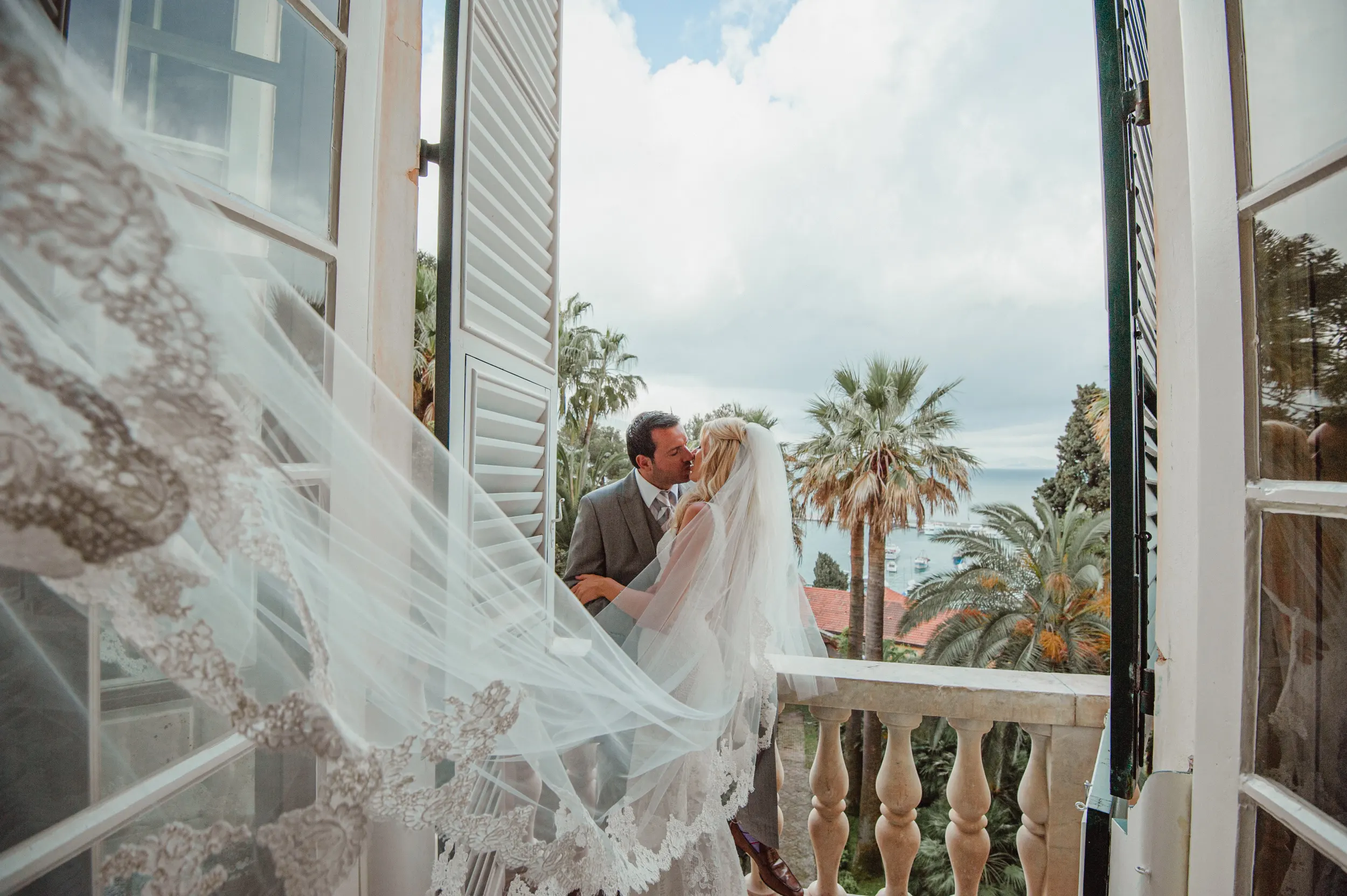 Bride and groom with a flowing veil on a Hotel Splendido balcony overlooking Portofino