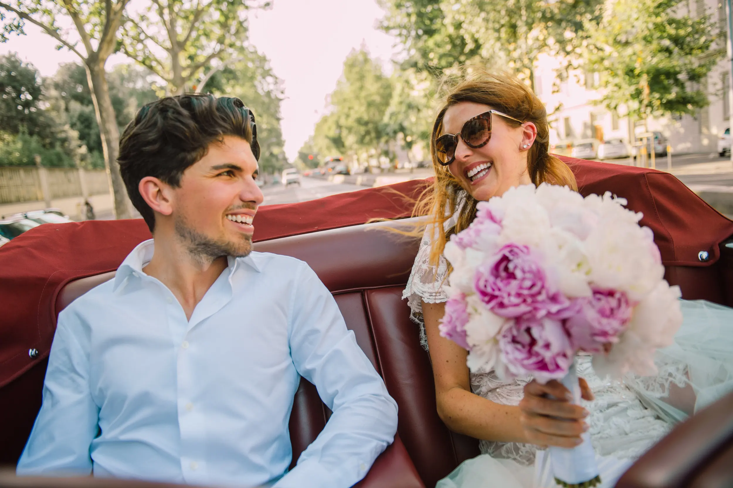 Bride and groom travelling in a cabriolet during an Italian destination wedding