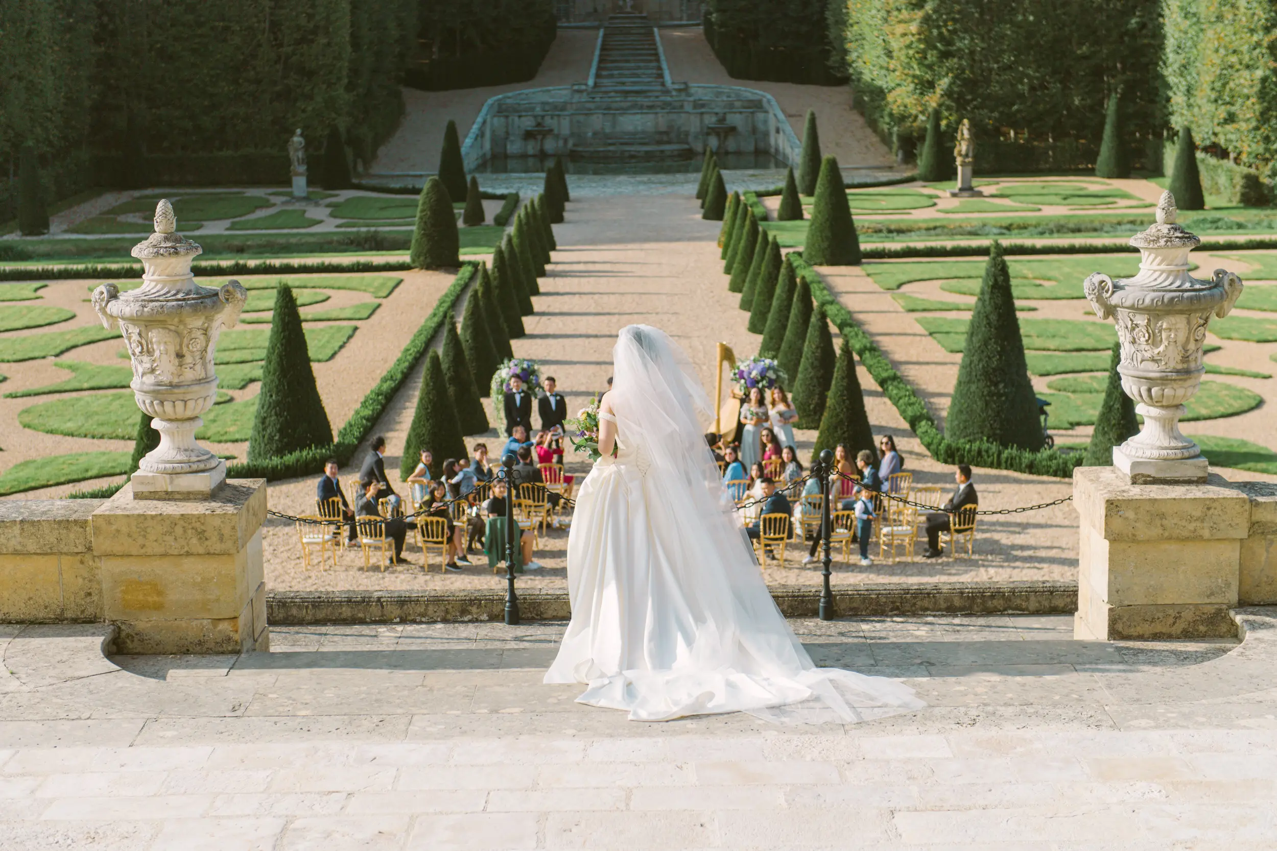 Bride walking to her outdoor wedding ceremony at Château de Villette