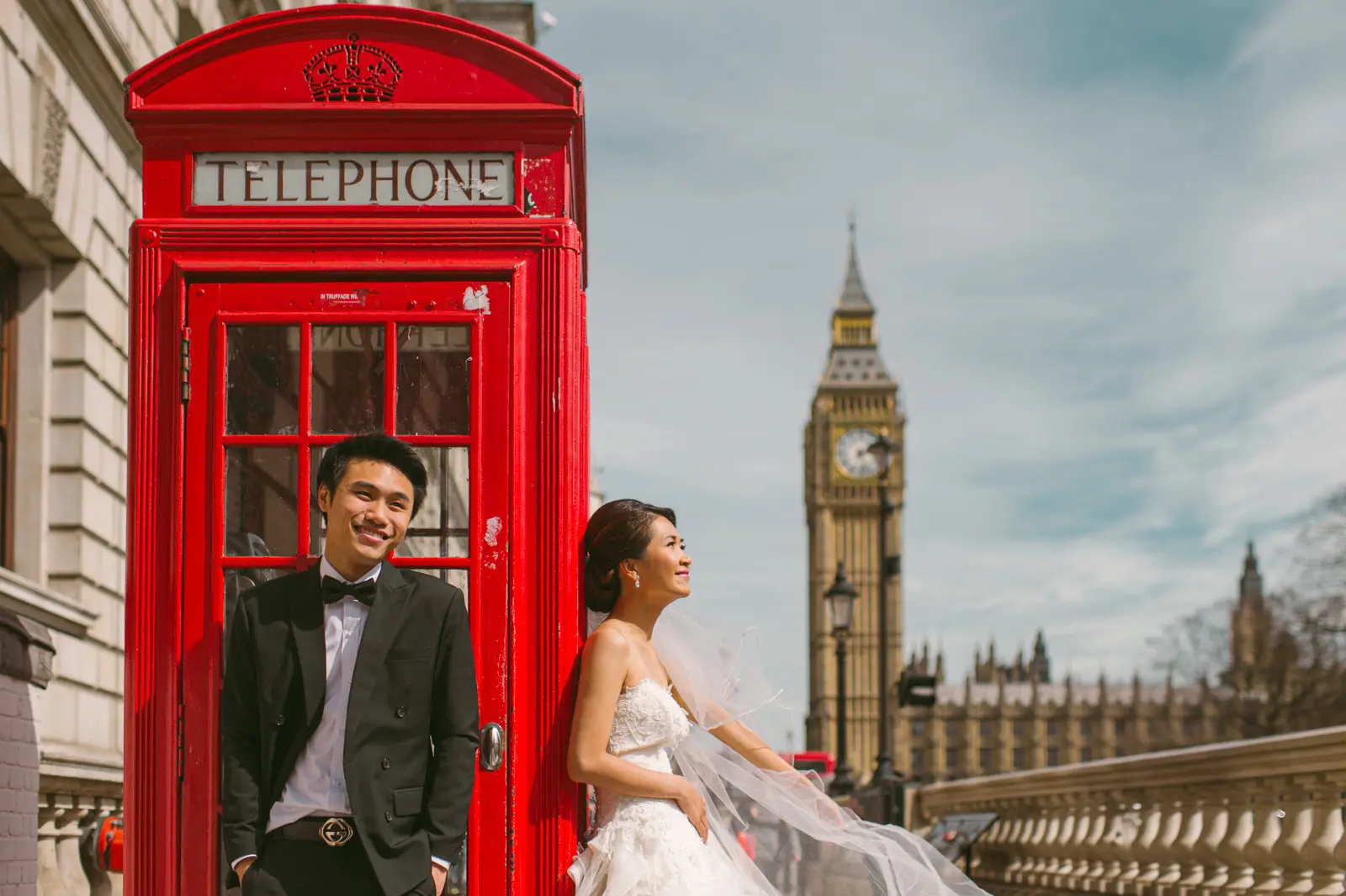 Couple posing near Big Ben and red telephone booth during London pre-wedding shoot