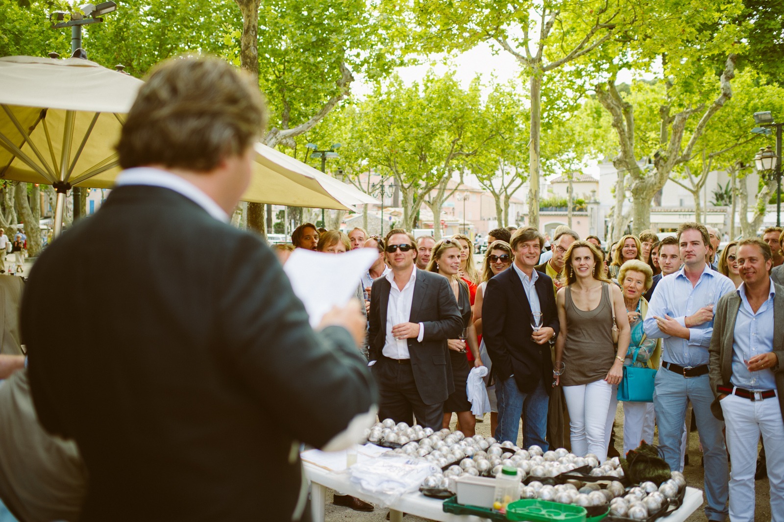 Wedding guests gathered around a boules field on the main square in Saint-Tropez