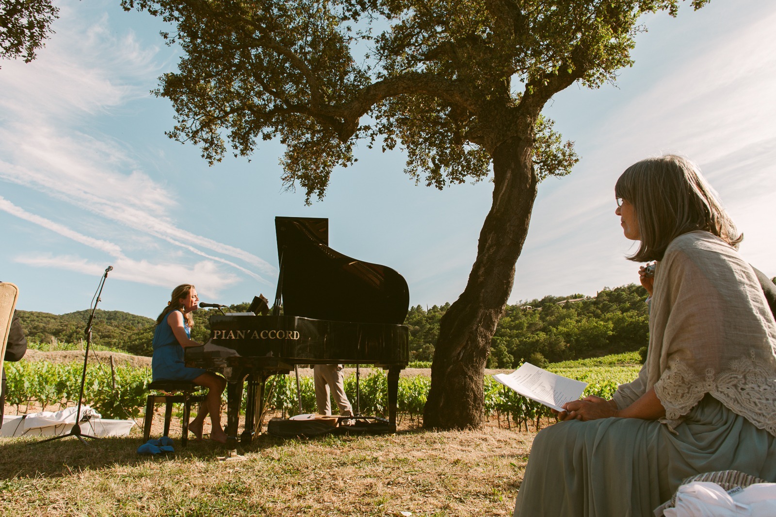Guests standing and talking under trees at vineyard wedding near Saint-Tropez
