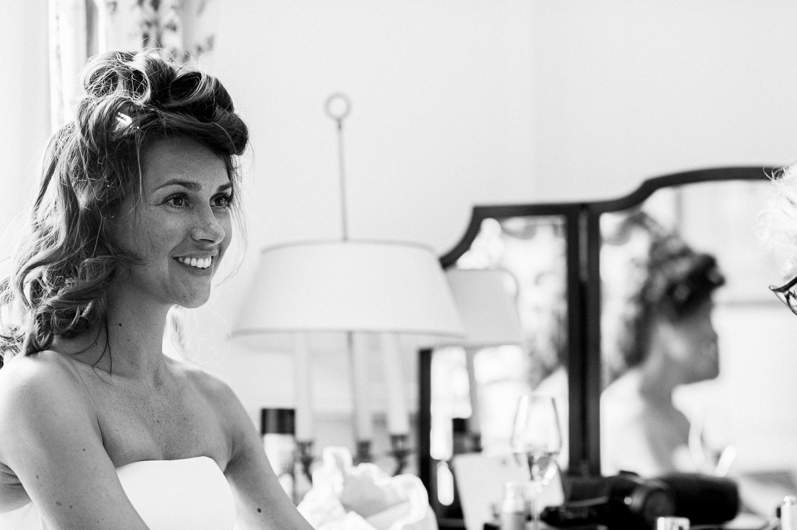 Groom buttoning his suit jacket in a Saint-Tropez hotel room