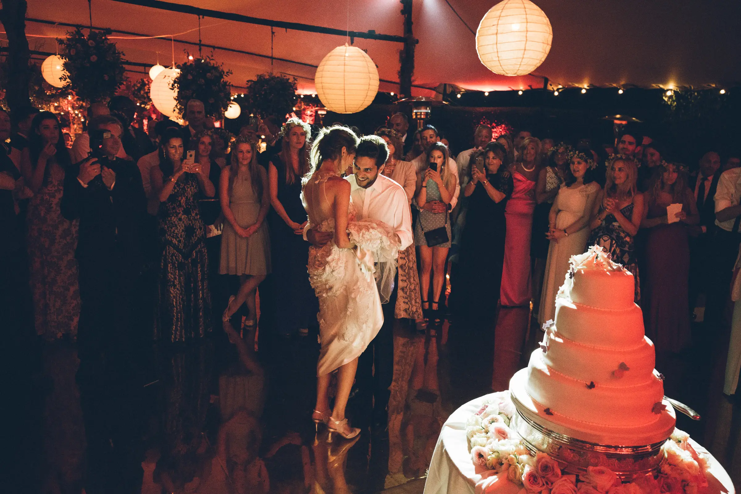 Bride and groom dancing during an outdoor tented wedding dinner in Tuscany
